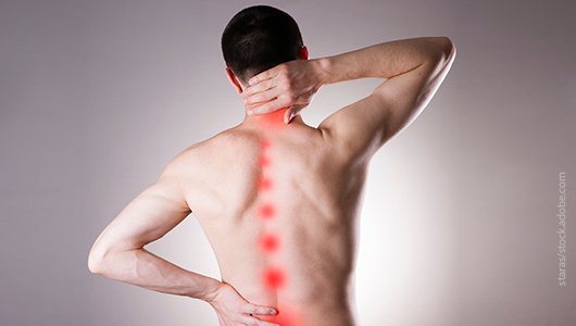 Schmerzzentrum Westfalen - Symbolbild: ein nackter männlicher Rücken mit rot markierten Schmerzpunkten an der Wirbelsäule